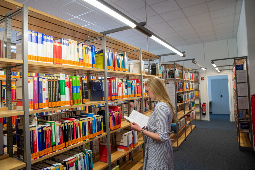 Person steht vor einem Bücherregal