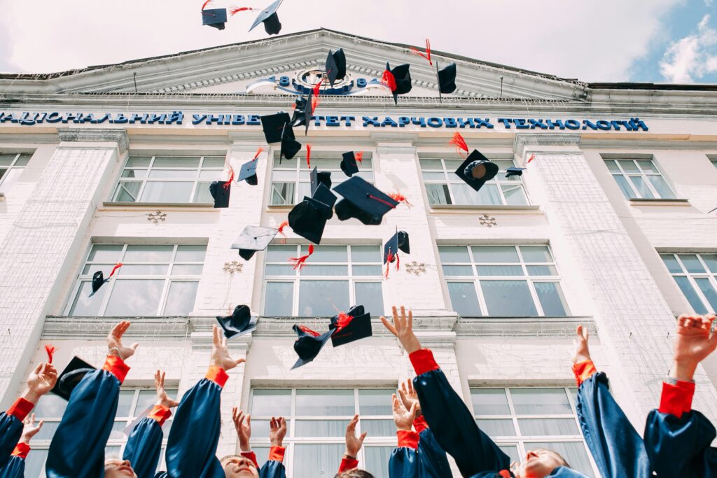 Studierende werfen Abschlusshüte hoch